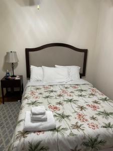 桑福德Sanford Lake Mary Quiet Rooms的一张带花卉床罩的床,上面有毛巾