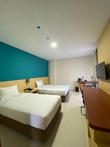 查亚普拉Erbe Style Jayapura Papua By Horison的酒店客房配有两张床和一张书桌