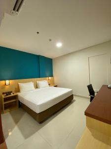 查亚普拉Erbe Style Jayapura Papua By Horison的一间卧室设有一张大床和蓝色的墙壁