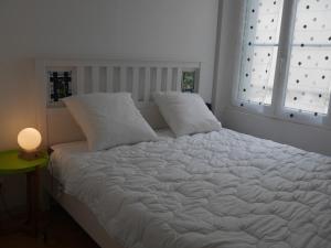 勒帕莱Appartement Le Palais, 3 pièces, 4 personnes - FR-1-418-225的卧室配有白色的床、两个枕头和窗户