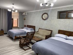 撒马尔罕Cinzano Complex的酒店客房,设有两张床和一张沙发