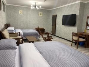 撒马尔罕Cinzano Complex的一间酒店客房,设有三张床和一台平面电视