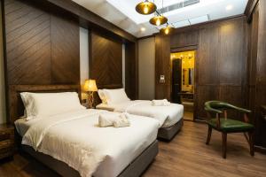 拉差汶里Khum Damnoen Resort的酒店客房,配有两张床和椅子