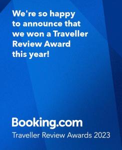 Giv‘at Koaẖאירוח השקד - 10דק' משדה התעופה的有一个蓝色的标志,欢迎宣布我们赢得了旅行者评审奖