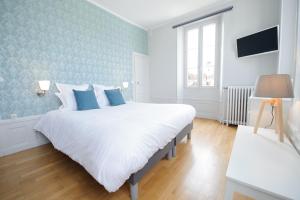 桑斯Villa Clément Sens Appart'Hotel的卧室配有白色大床和蓝色的墙壁