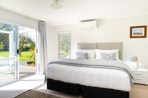 克莱夫Amuri Villas的白色卧室设有一张大床和一个滑动玻璃门