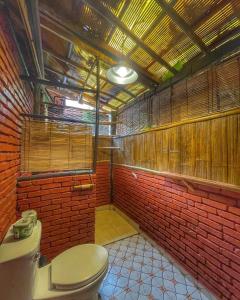 琅勃拉邦莎莎劳酒店的一间带卫生间和红砖墙的浴室