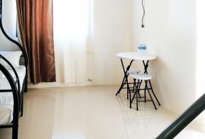 班塔延岛L and V Bantayan Guest House的一个小桌子和两个凳子