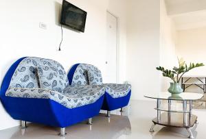 班塔延岛L and V Bantayan Guest House的一张蓝色椅子,放在带桌子的房间