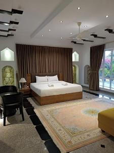 Al JināhValley CLIFF INN的一间卧室配有一张床、一张桌子和一把椅子