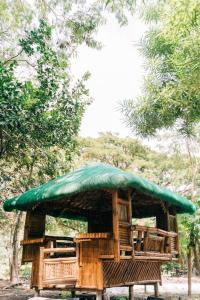 LuboFamily Dome Glamping in Rizal with Private Hotspring的凉亭设有绿色屋顶和椅子