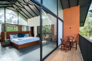 瓦亚纳德Crystal Kuruva Nature Resort & Spa的一间卧室,阳台上配有一张床和一张桌子
