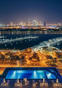 迪拜班达罗塔纳 - 迪拜河酒店的游泳池,享有夜间城市美景