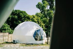 LuboTranquil Retreat Dome Glamping with Hotspring Dipping pool - Breathtaking View的围栏前的白色圆顶帐篷