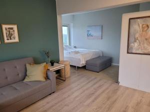 埃斯波TapiolaSky: airy, bright, great bed and spacious - close to Aalto campus and Tapiola center的客厅配有沙发和1张床