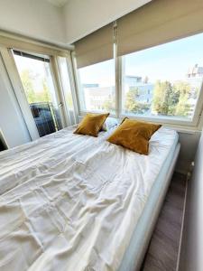 埃斯波TapiolaSky: airy, bright, great bed and spacious - close to Aalto campus and Tapiola center的一张大床,位于带大窗户的房间里