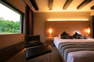 二世古二世古北方安努普利度假酒店的卧室配有床、椅子和窗户。
