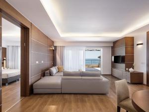 普拉塔尼亚斯Minoa Palace Resort的带沙发和电视的客厅