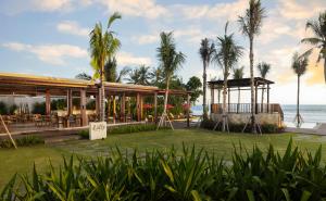 塔巴南Amarta Beach Retreat by Nakula的一个带凉亭和棕榈树的度假村