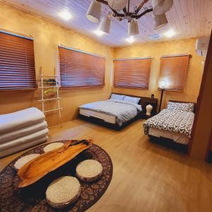木浦市Leehakjang guesthouse的客房设有两张床、一张桌子和窗户。