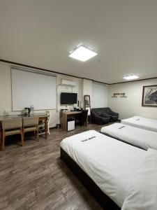 木浦市Ekonomy Hotel的酒店客房设有两张床和投影屏幕