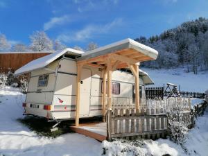 上施陶芬Leihwohnwagen Camping-Aach的雪中带木甲板的拱形