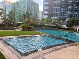 马尼拉Uptown Parksuites II的一座位于城市的游泳池,有高大的建筑
