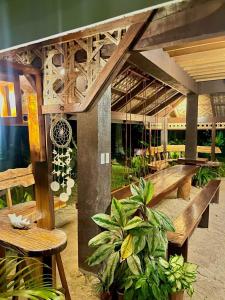 卢纳将军城Isola del Sole Villas and Resort的庭院设有木长椅、桌子和植物