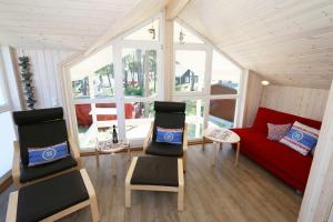 巴贝Ferienhaus Traumzeit - Strandpark (strandnah)的客厅配有红色的沙发和两把椅子