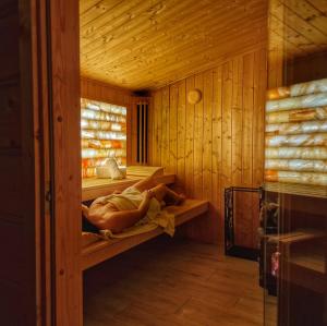 拉普斯尼恩LK Resort Łapsze domy z prywatną balią i sauną的躺在桑拿架上的女人