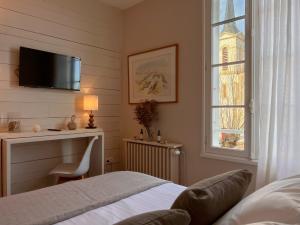 圣克莱门特德巴穿靴子的猫酒店的一间卧室配有一张床、一张书桌和一个窗户。