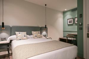 巴塞罗那维亚奥古斯塔酒店的一间卧室设有一张带绿色墙壁的大床