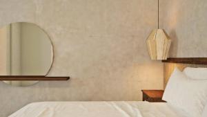 阿里奥波利斯埃里奥珀里斯精品酒店的卧室配有白色的床和镜子