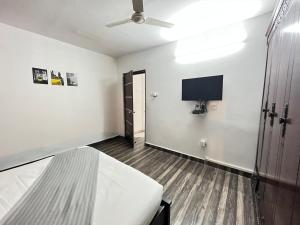 海得拉巴BedChambers Serviced Apartment, Jubilee Hills的一间卧室配有一张床和一台平面电视