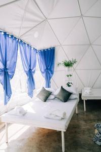 LuboFamily Fun Dome Glamping with Hotspring Pool (6 pax)的配有蓝色窗帘的白色沙发