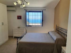 锡拉库扎Appartamento - Plemmirio的一间卧室配有床、窗户和梳妆台