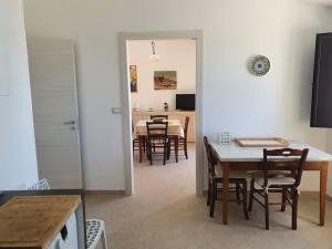 锡拉库扎Appartamento - Plemmirio的厨房以及带桌椅的用餐室。