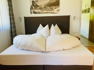 普范德斯Haus Schuchter的一张带白色床单和枕头的床