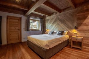 阿亚斯Fleur des neiges & Spa - Adults only的木制客房内的一间卧室配有一张大床
