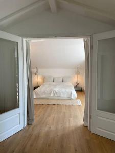 LangscheidSorpe Lodge - Entspannte Urlaubstage am See!的一间白色卧室,配有床和电视