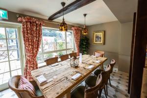 赛伦塞斯特Eliot Arms的用餐室配有大型木桌和椅子