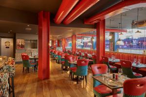 曼彻斯特马尔马逊曼切斯特酒店的餐厅设有红色圆柱和桌椅