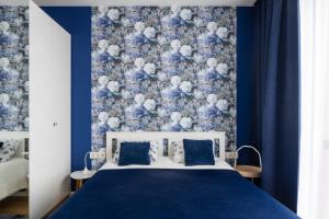 里加1-bedroom penthouse with underground parking的蓝色的卧室,配有一张蓝色和白色的墙壁床
