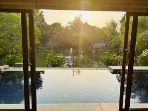 农布Pool Villas by Honey-5 miles from central Pattaya Beach的滑动玻璃门享有游泳池的景致