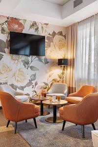 卡尔斯鲁厄Styles Hotel Karlsruhe Messe的客厅配有椅子和鲜花墙