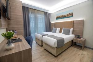 伊斯坦布尔The Omiya Hotel的配有一张床和一张书桌的酒店客房