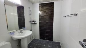济州市The Oakra Hotel的浴室配有盥洗盆和带镜子的淋浴