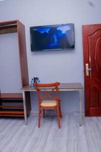 基苏木The VIP Luxury Lounge Hotel的一张桌子、椅子和墙上的电视