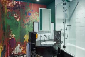 曼彻斯特马尔马逊曼切斯特酒店的一间带水槽的浴室和墙上的绘画