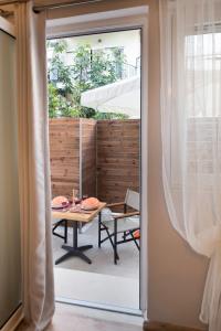 雷夫卡达镇LEFKAS CITY APARTMENTS & SUITES的滑动玻璃门通向带桌子的庭院